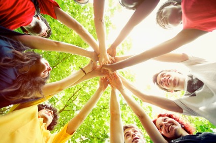 Group of people with their hands together.