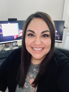 Isela smiling happily in front of her computer. 